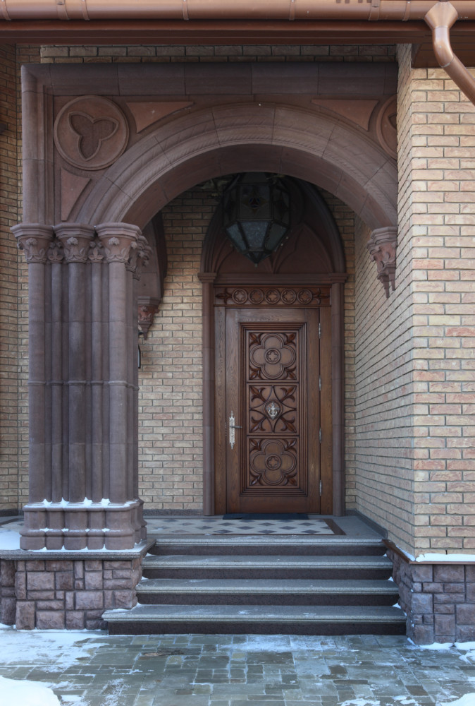 Декорирование существующего кирпичного фасада в стиле неоготика.
Материал: цветной архитектурный бетон.
Входная дверь из массива дуба.