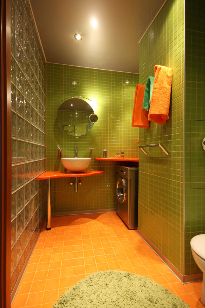 В ванной для отделки использована мозаичная плитка и стеклоблоки.