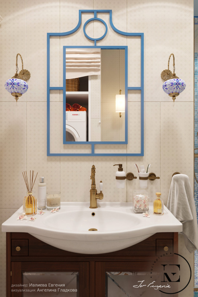 На светлом фоне стены хорошо выделяется темная тумба под раковиной. Некоторые аксессуары: держатели для полотенца и ванных принадлежностей выдержаны в том же цвете. Металлический смеситель хорошо перекликается с держателями у бра. Самое интересное в этом интерьере - зеркало с синей тонкой рамочкой выполненной в стиле прованс.